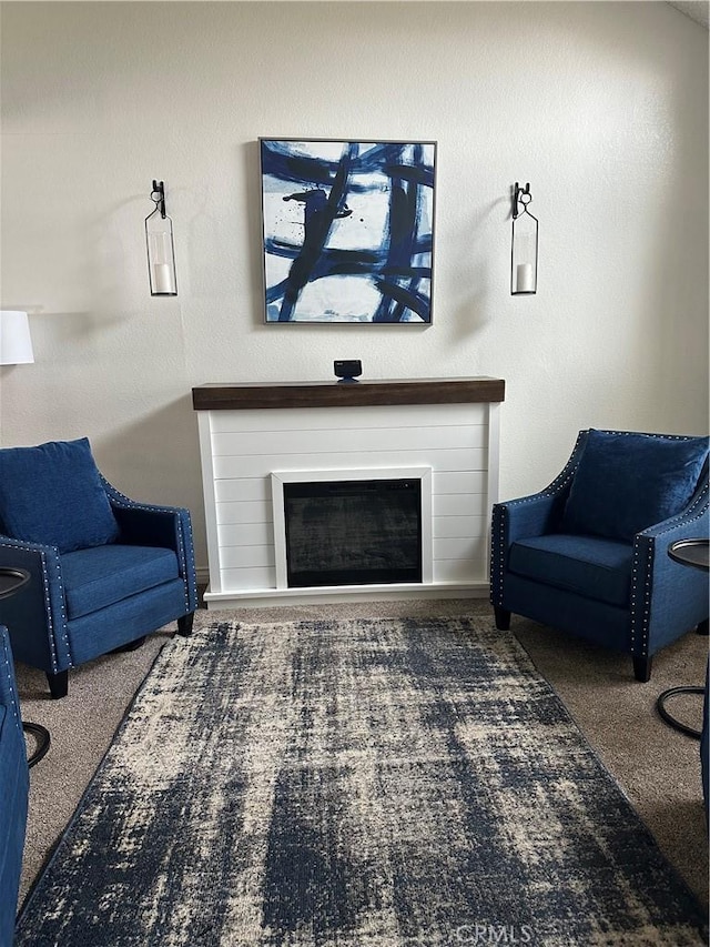 carpeted living room with baseboards and a glass covered fireplace