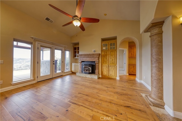 unfurnished living room with a ceiling fan, visible vents, arched walkways, light wood-type flooring, and high vaulted ceiling
