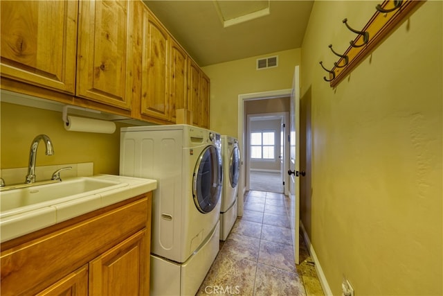 laundry room with visible vents, washer and dryer, baseboards, a sink, and cabinet space