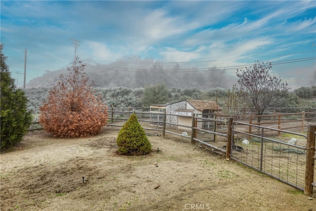 view of yard featuring an outdoor structure and a rural view