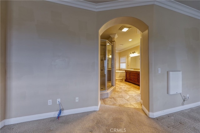 interior space featuring arched walkways, baseboards, light colored carpet, and ornamental molding