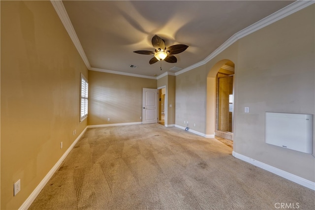 spare room with arched walkways, ornamental molding, carpet, and a ceiling fan