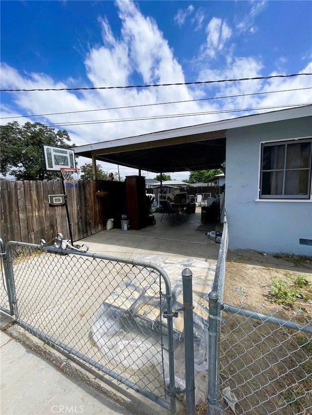 view of patio / terrace featuring fence, a gate, and a carport