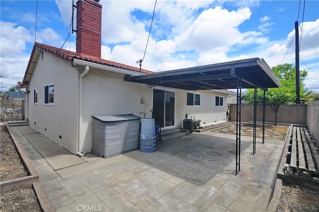 back of property with fence, stucco siding, a chimney, a patio area, and a tile roof