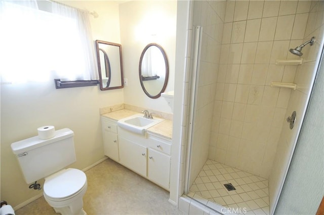 full bathroom with vanity, baseboards, a stall shower, and toilet