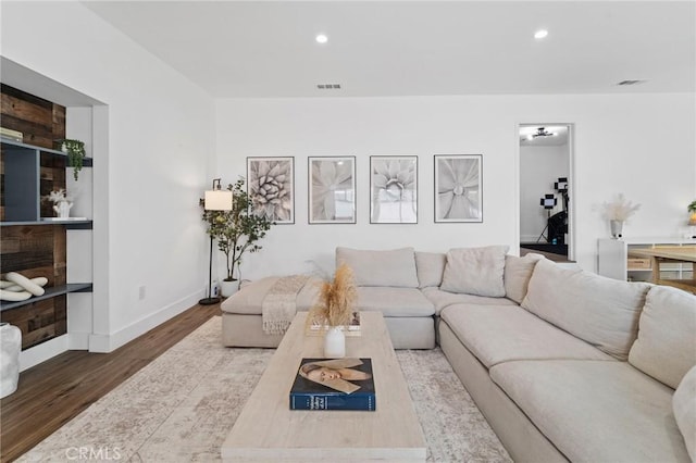 living room with recessed lighting, baseboards, wood finished floors, and visible vents