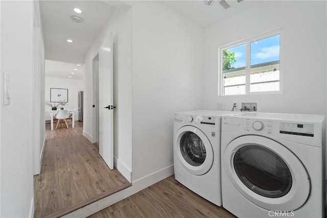 clothes washing area featuring laundry area, washing machine and dryer, baseboards, light wood finished floors, and recessed lighting