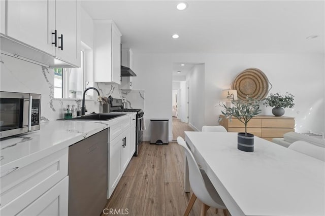 kitchen featuring light countertops, stainless steel appliances, white cabinetry, and a sink