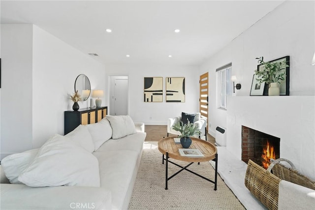 living area with recessed lighting, a brick fireplace, and visible vents
