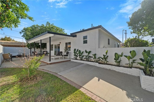back of house featuring a patio, a fenced backyard, and stucco siding