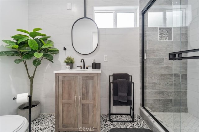 full bath featuring vanity, a shower stall, toilet, and tile walls