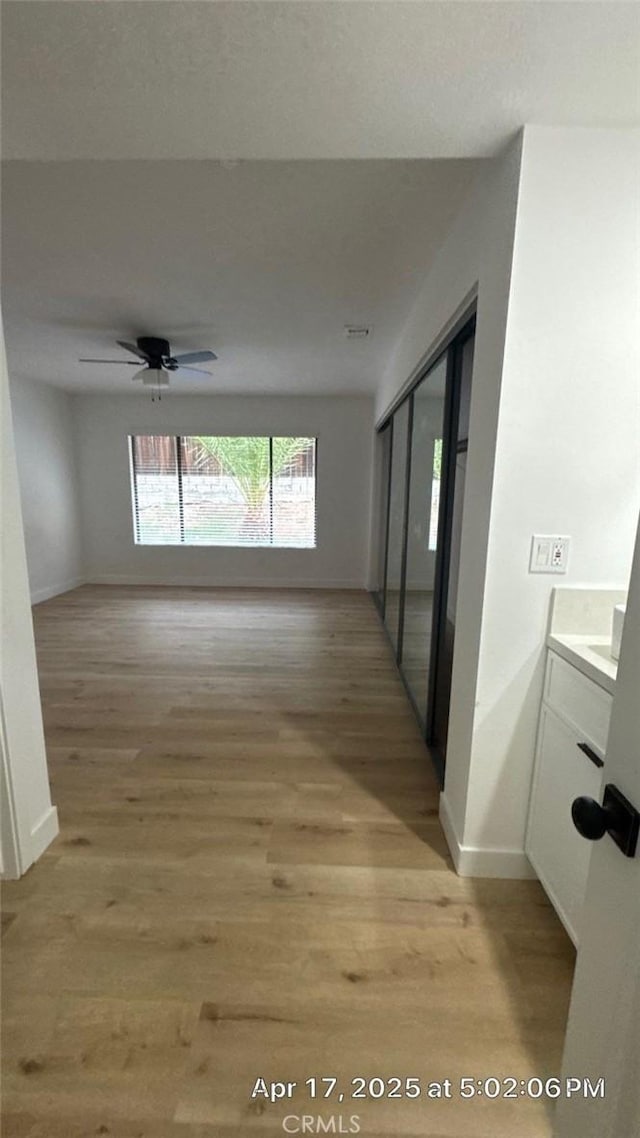 hall with baseboards and light wood finished floors
