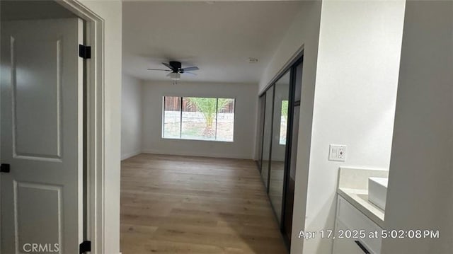 hallway featuring baseboards and light wood-type flooring