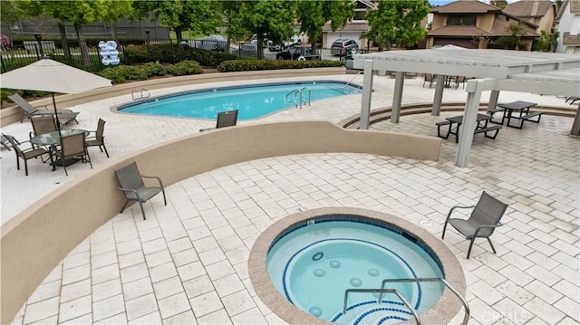 pool featuring a patio area, a hot tub, and fence