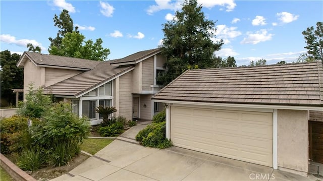 view of front of house with a tiled roof, driveway, and a garage