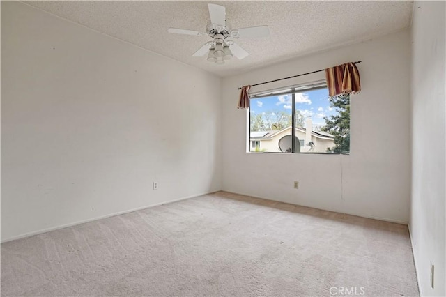 unfurnished room featuring a textured ceiling, light colored carpet, and ceiling fan