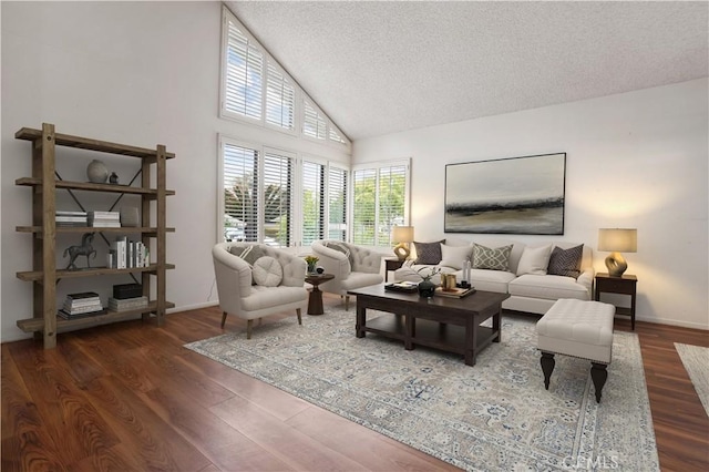 living room with baseboards, a textured ceiling, high vaulted ceiling, and wood finished floors