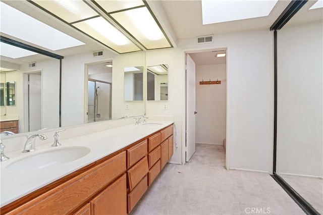 bathroom featuring a skylight, visible vents, and a sink