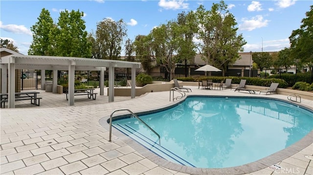 community pool with a patio, fence, and a pergola