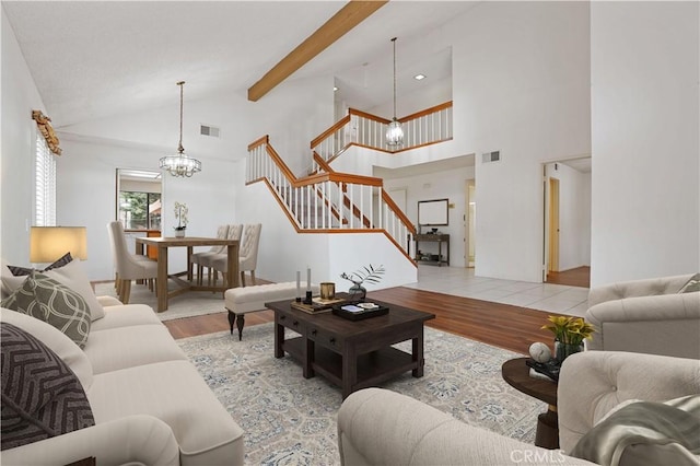 living room with an inviting chandelier, stairs, wood finished floors, and visible vents