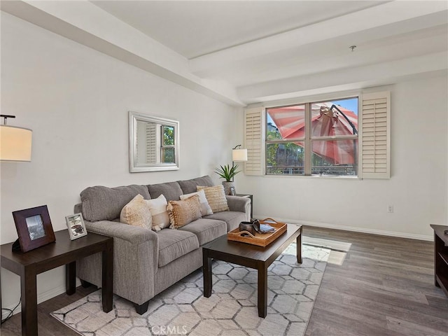 living room with baseboards, beamed ceiling, and wood finished floors