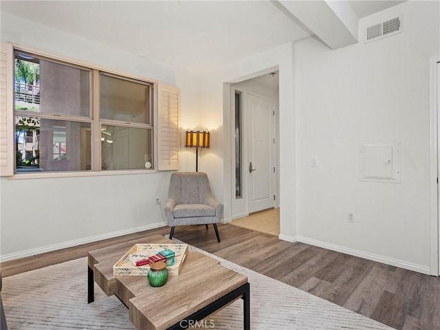 sitting room with visible vents, baseboards, and wood finished floors