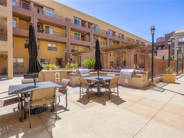 view of patio featuring exterior kitchen, outdoor dining space, and grilling area