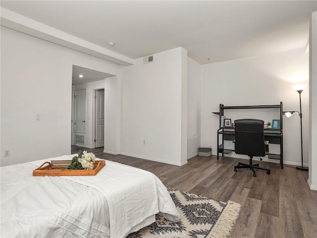 bedroom featuring baseboards, wood finished floors, and visible vents