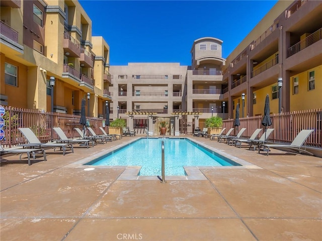 pool with fence and a patio area