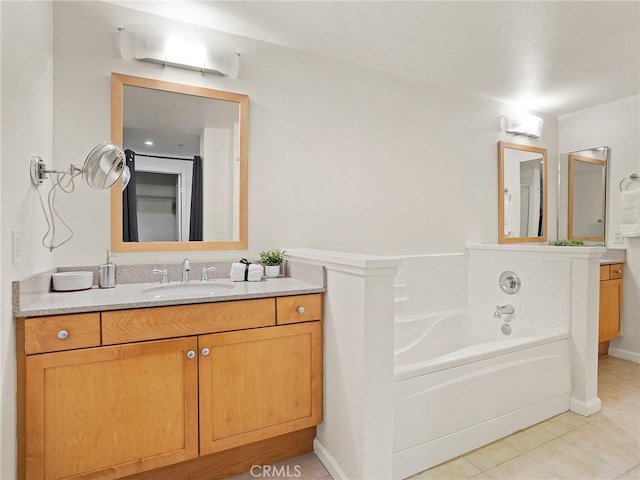 full bath featuring tile patterned floors, a garden tub, and vanity