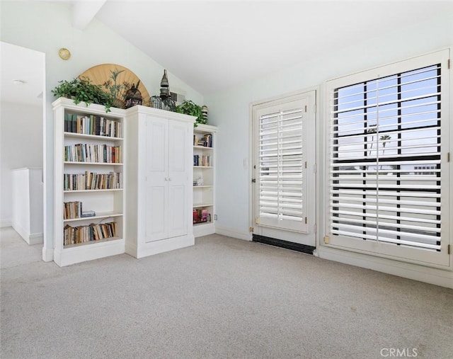 interior space with lofted ceiling with beams, a healthy amount of sunlight, and carpet