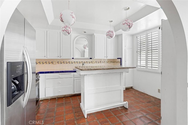 kitchen with decorative backsplash, stainless steel refrigerator with ice dispenser, tile countertops, and white cabinetry