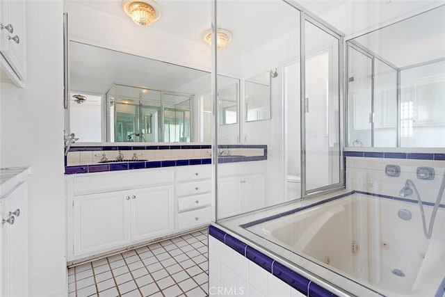 full bath featuring tile patterned floors, a jetted tub, and vanity