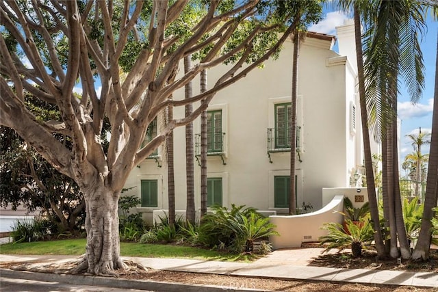 view of property exterior with stucco siding and a chimney