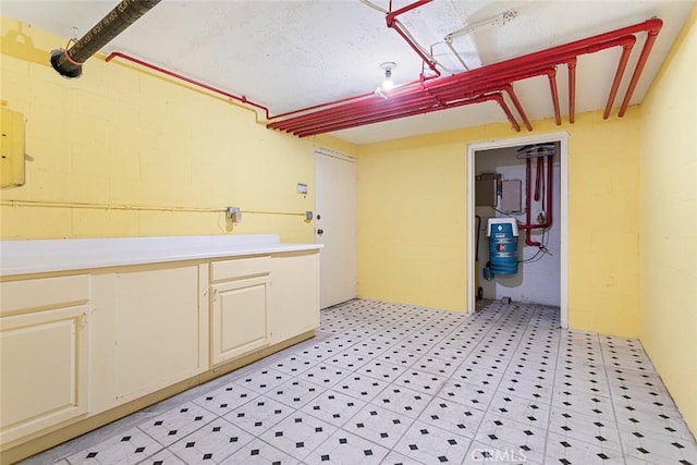 laundry area featuring concrete block wall and light floors