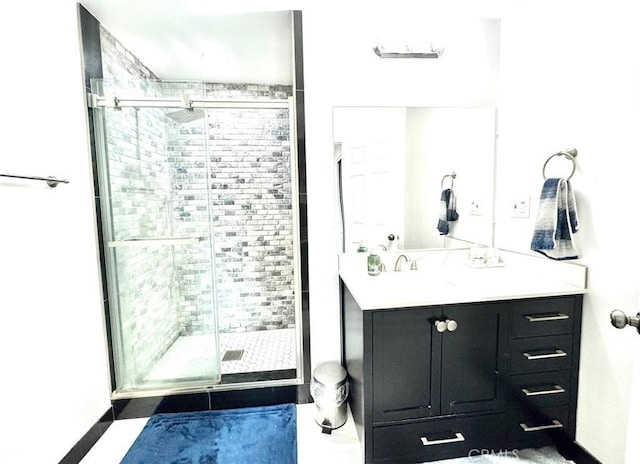 full bath featuring vanity, baseboards, and a shower stall