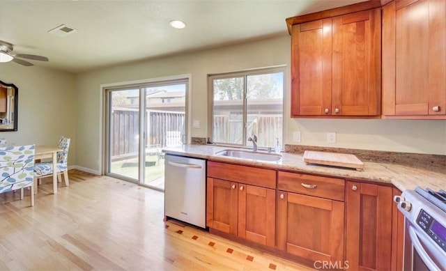 kitchen featuring visible vents, a sink, light wood finished floors, and stainless steel appliances