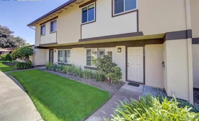 view of front of property with a front yard and stucco siding