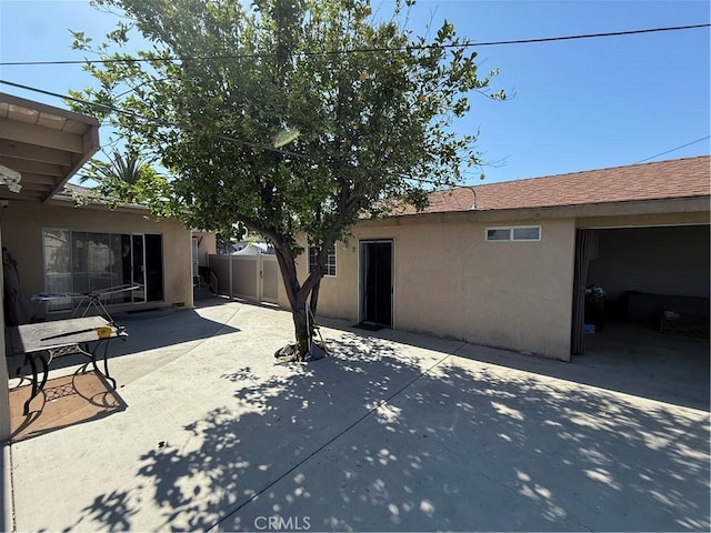 back of house featuring a patio area, stucco siding, and fence