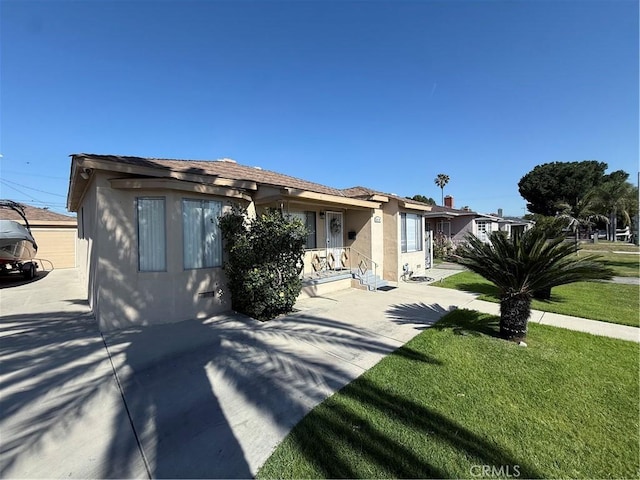 view of front of home featuring stucco siding and a front lawn