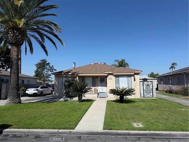 bungalow-style house featuring roof with shingles, stucco siding, and a front lawn