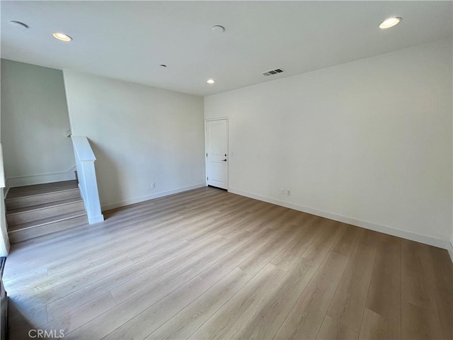 unfurnished living room with recessed lighting, baseboards, and wood finished floors