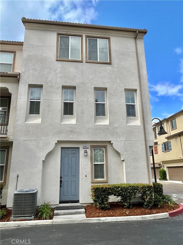 townhome / multi-family property featuring stucco siding and cooling unit