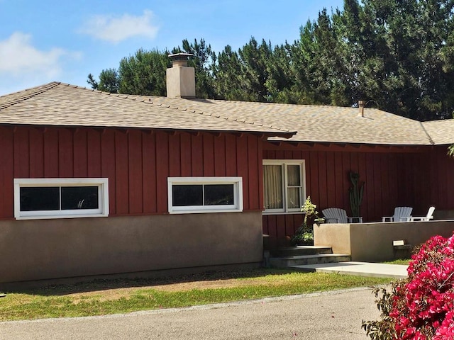 view of home's exterior featuring roof with shingles and a chimney