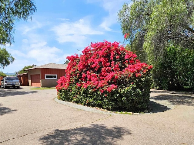 view of property exterior featuring an outbuilding, an attached garage, and driveway
