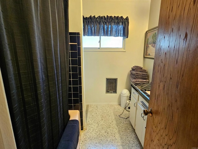 bathroom featuring visible vents, vanity, toilet, baseboards, and speckled floor