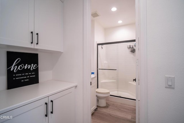 bathroom with visible vents, a shower stall, wood finished floors, toilet, and recessed lighting