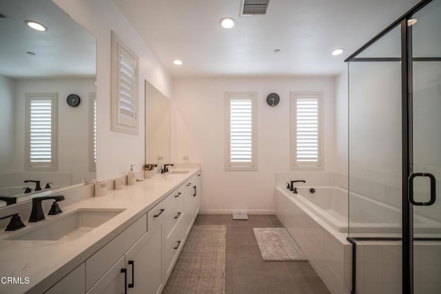 full bath with a sink, a wealth of natural light, recessed lighting, and visible vents