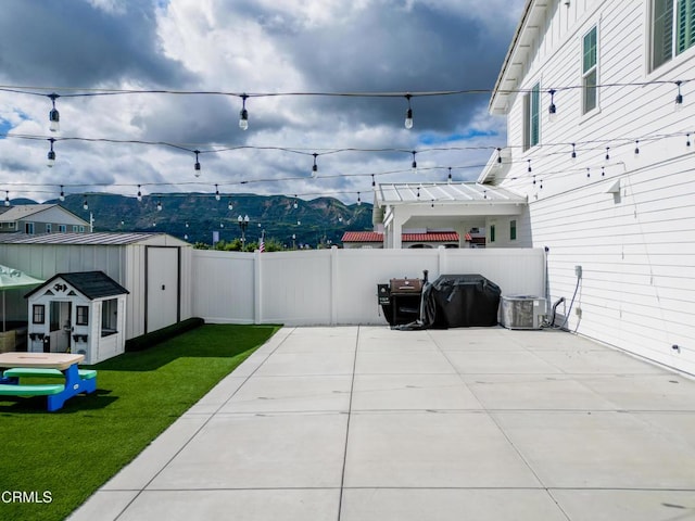 view of patio with central AC, an outdoor structure, a fenced backyard, a storage unit, and a pergola