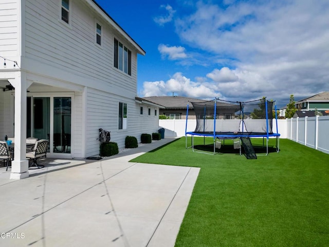 view of yard with a fenced backyard, a trampoline, and a patio area